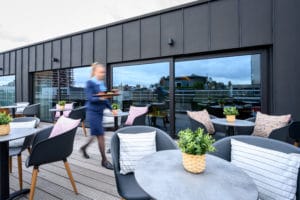 PREMIER SUITES PLUS Antwerp terrace 7th Heaven Food Café woman serving