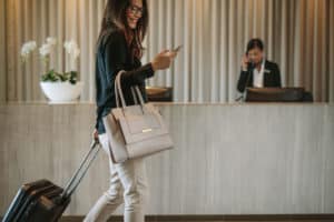 Gast controleert haar telefoon als ze incheckt in een hotel