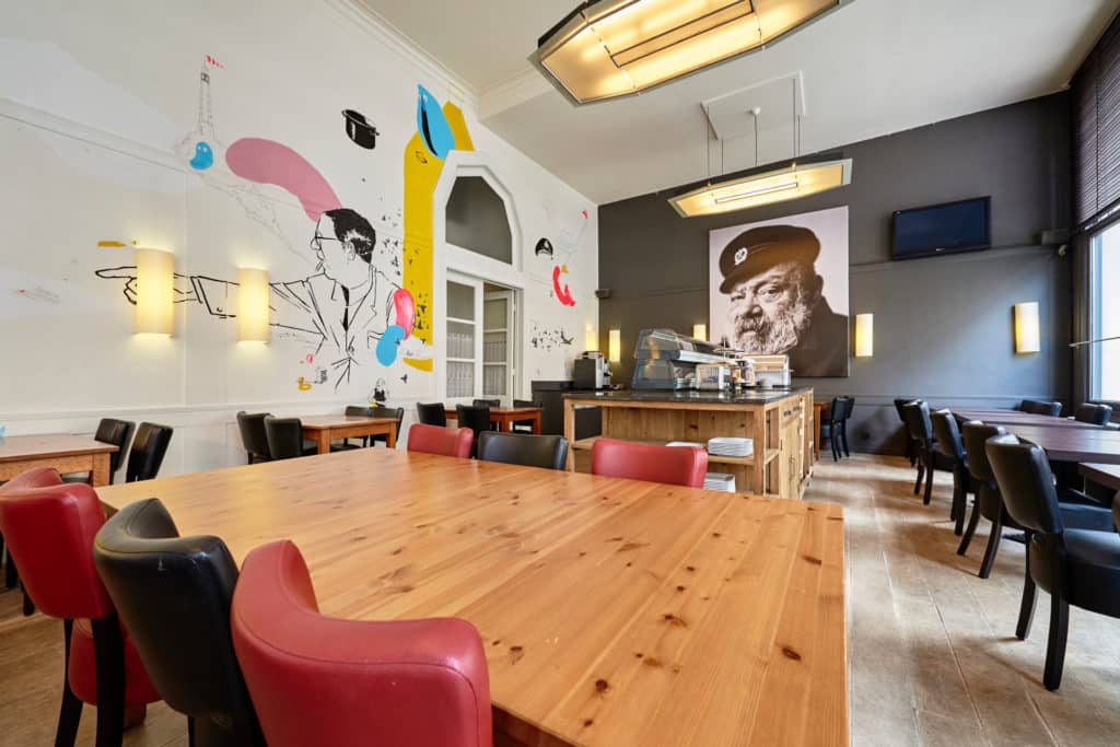 Leopold Hotel Oostende Ontbijtzaal Tafels en versierde zijwand